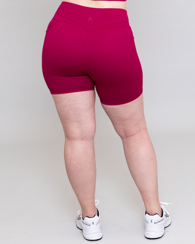 Person wearing magenta shorts on a plain background