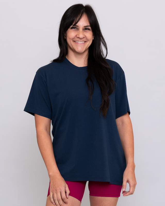 Woman wearing a navy blue t-shirt and maroon shorts on a white background