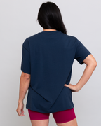Person wearing a navy blue top and pink shorts on a light gray background