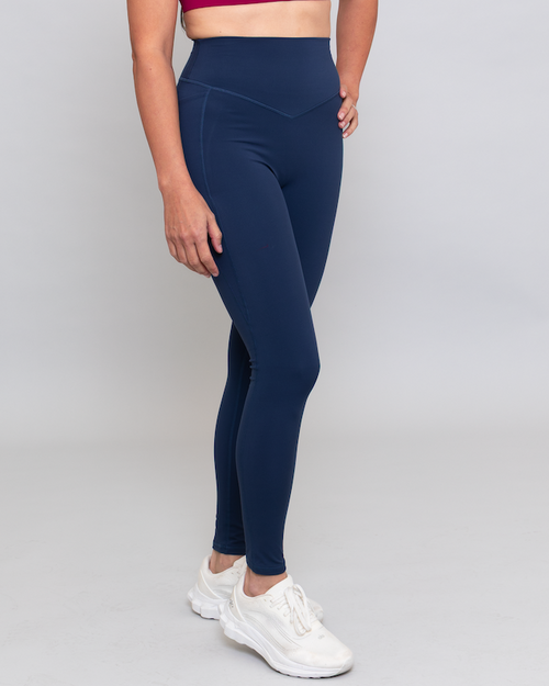 Person wearing navy leggings on a gray background